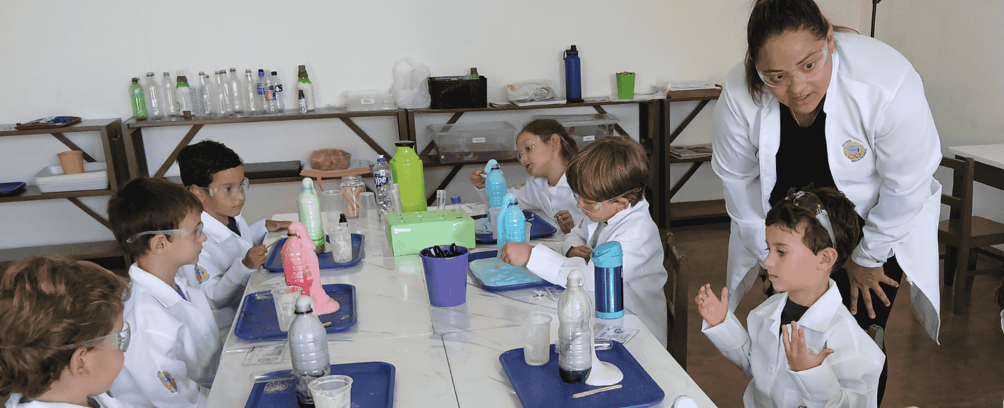 Substitua por uma foto de uma criança investigando uma experiência
